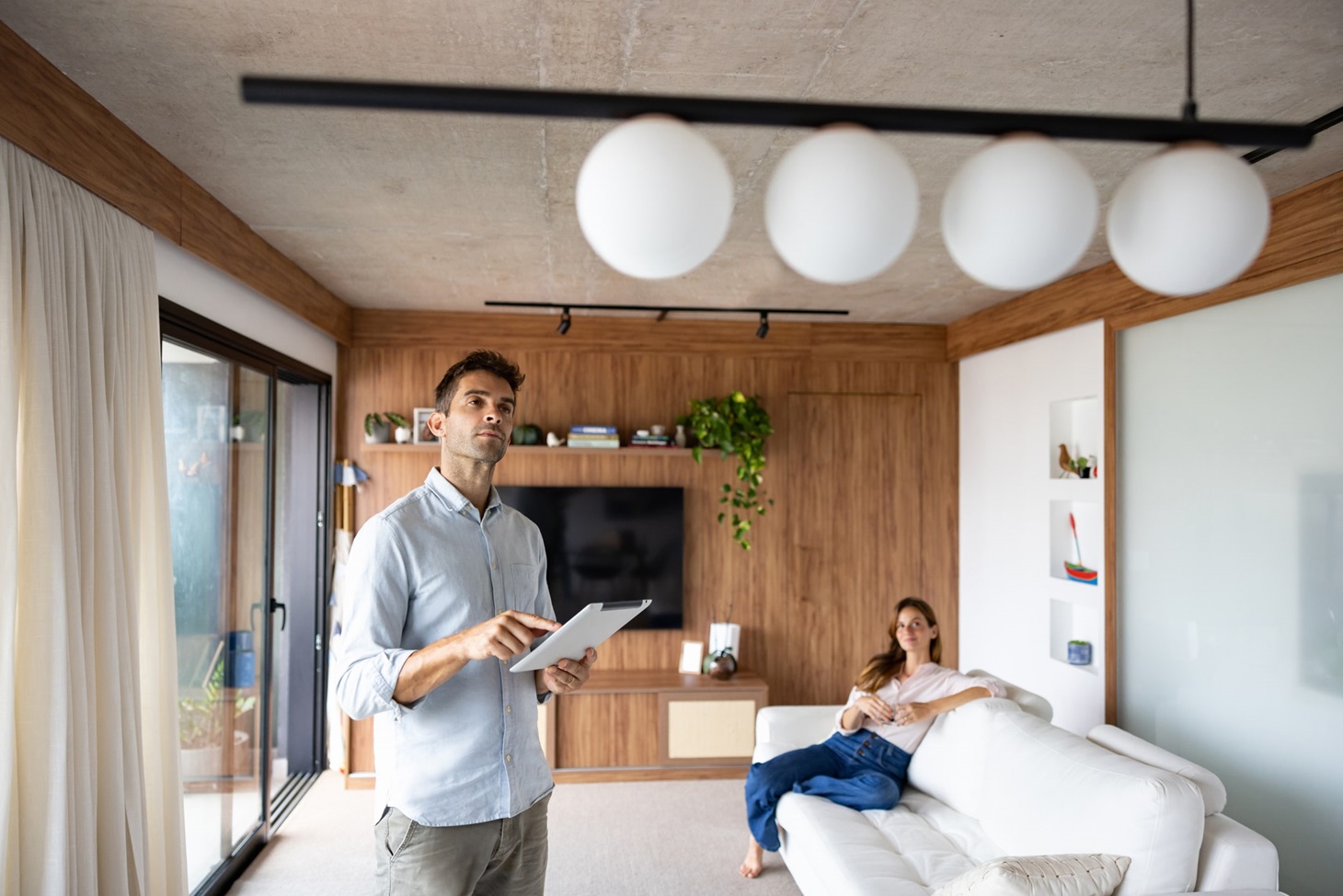 Eurolife Blog_Άνθρωπος που ελέγχει τα φώτα στο σπίτι του χρησιμοποιώντας ένα αυτοματοποιημένο σύστημα_smart home